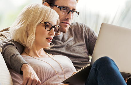 couple both with glasses on - sitting on couch