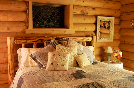 A bed in a hotel room with a log-cabin feel