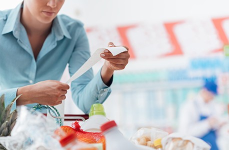 Woman checking savings on grocery store receipt