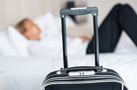 man with luggage in hotel room