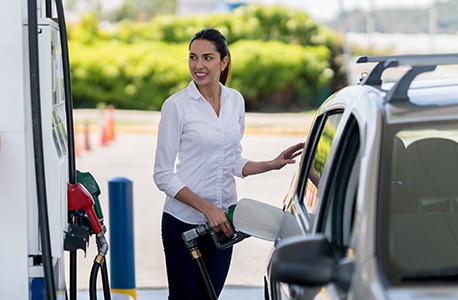 Woman pumping gas.