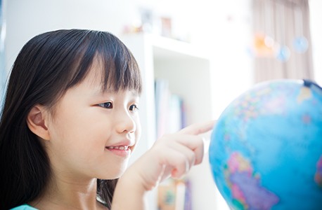 child looking at globe