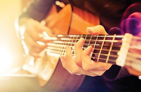 musician playing acoustic guitar
