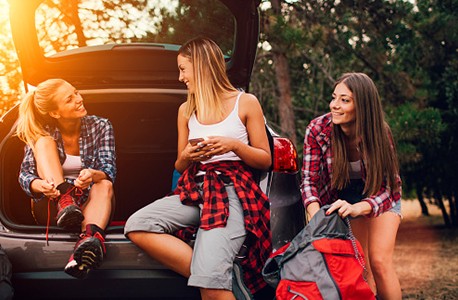 3 women behind car in outdoors