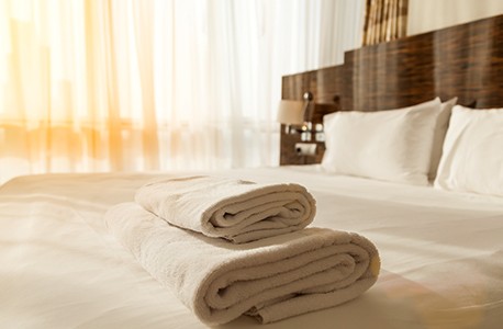 A bed with folded towels resting on the foot