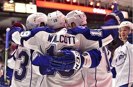 A photo of Syracuse Crunch hockey players celebrating after a goal