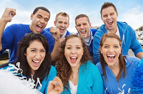 College students wearing blue and cheering on a team