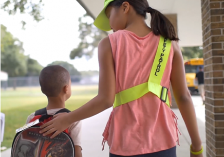 student walks with safety patroller